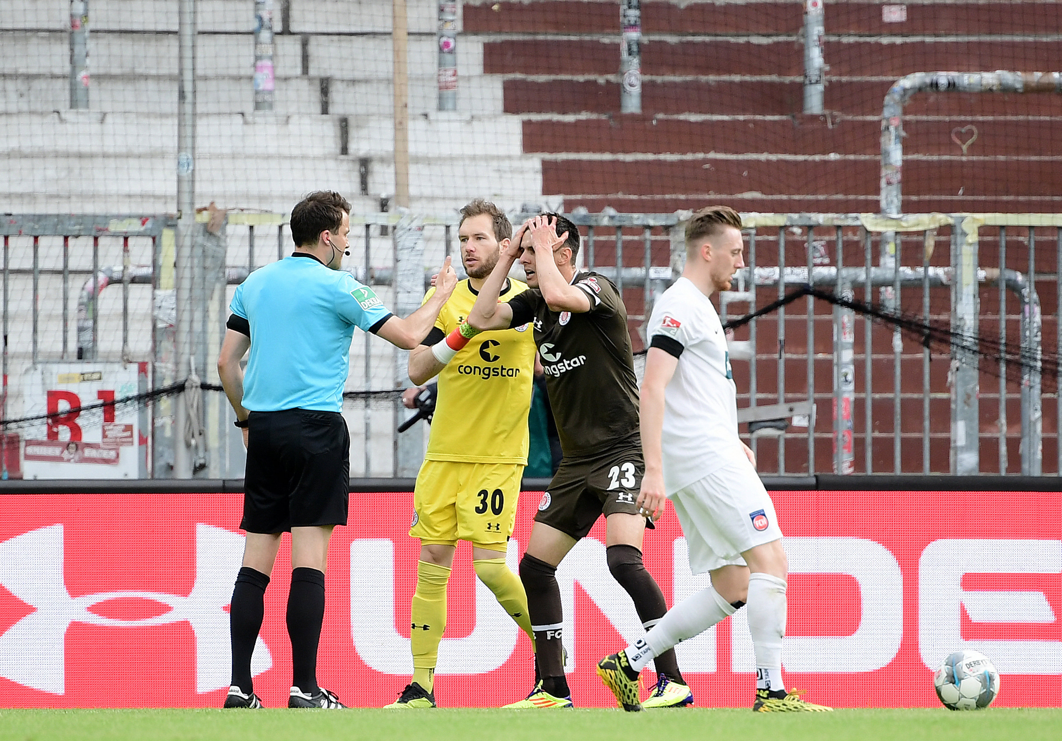 The main talking point in the first half: referee Lasse Koslowski (left) awards a penalty to the consternation of Johannes Flum (centre right).